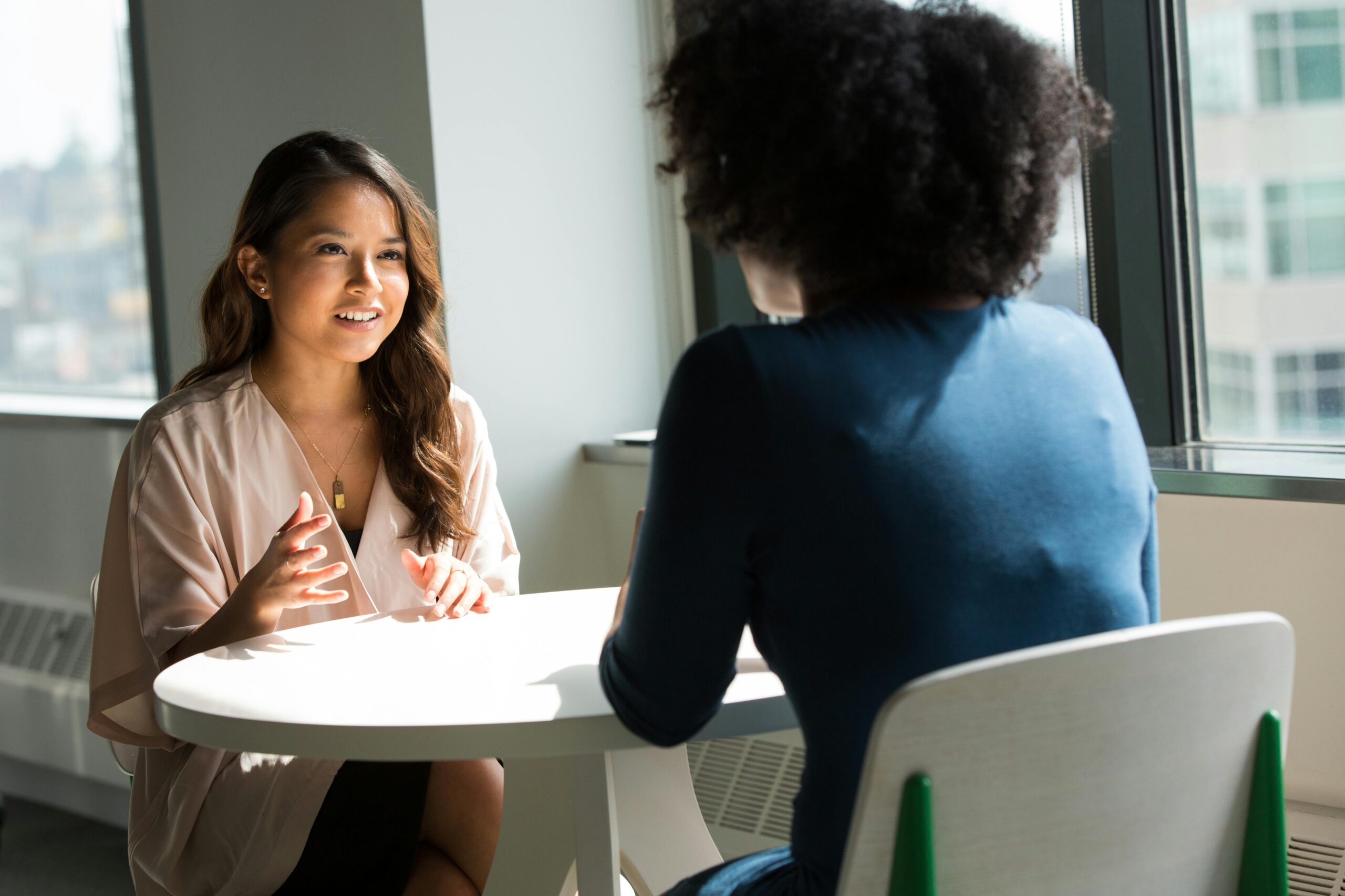 Two colleagues face-to-face in the office, participating in peer coaching.