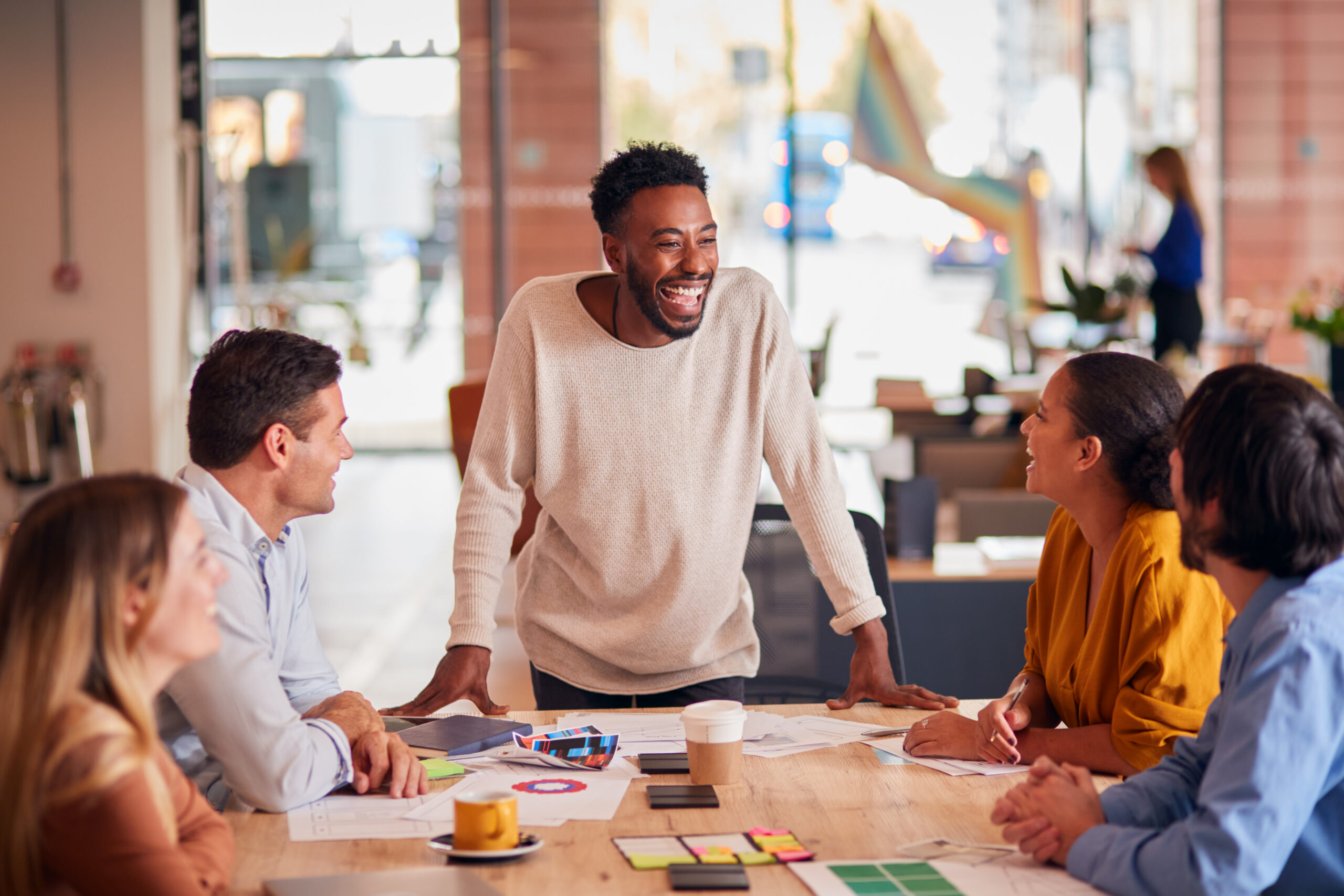 Entry-level marketing professionals collaborating around a table during a strategy session.