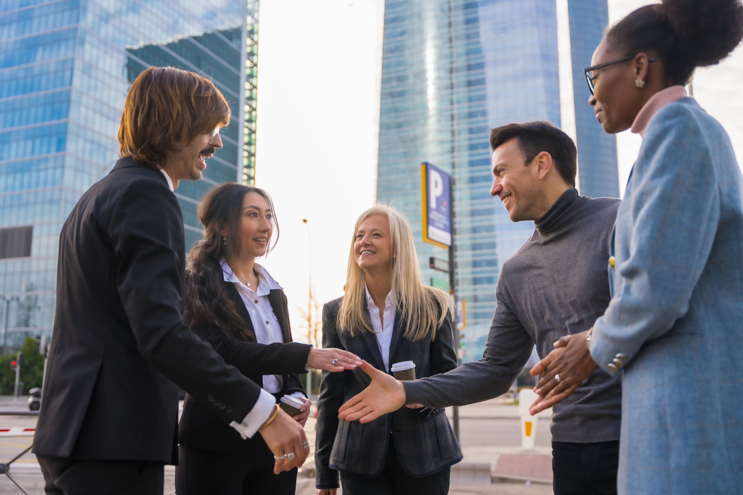 Professionals networking outdoors and exploring sales internships in a modern business district.
